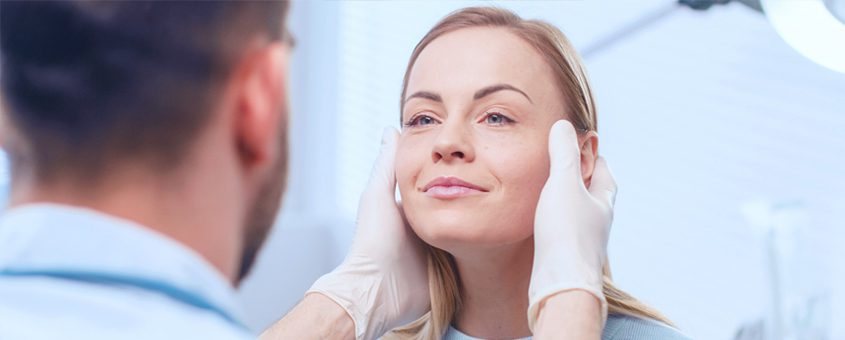 img-botox Woman smiling at dentist during oral examination in dental clinic setting.