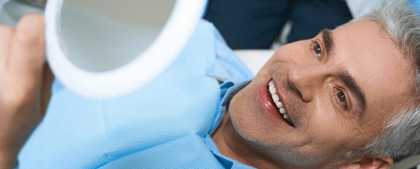 Patient reclines in dental chair, smiling during examination at CopperMine Dental Studio.