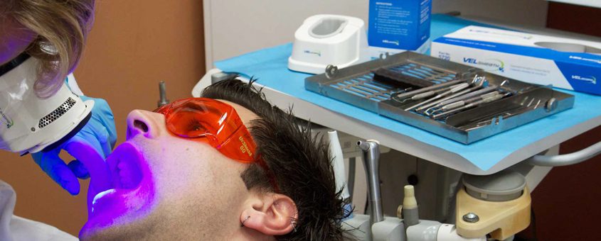 img-velscope Patient receiving dental treatment under purple and red overhead lights at CopperMine Dental Studio.