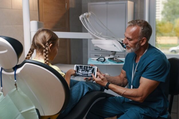 Dentist explaining root canal vs tooth extraction options for oral health.
