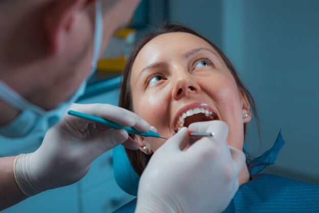 Patient receiving a professional dental checkup from a dentist in a clinic.