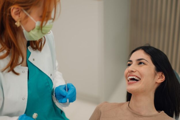 Woman smiling confidently after a routine dental checkup and cleaning.