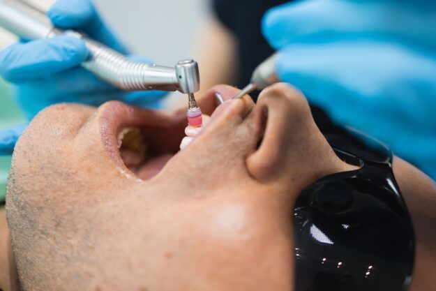 Dental hygienist performing teeth cleaning on a patient in a Green Valley dental office.