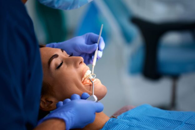 Dentist examining a patient’s teeth during a dental check-up.