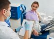 Family dentist reviewing and updating a patient’s dental history during a routine checkup in a modern dental office.