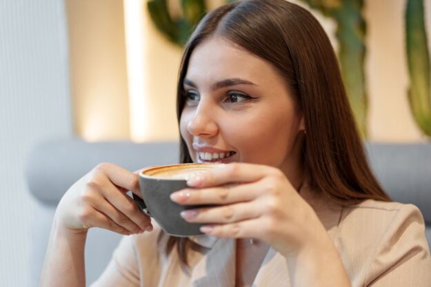 A woman enjoying coffee during Invisalign treatment while keeping aligners safe and teeth protected.