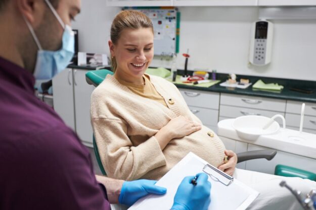Pregnant woman smiling during a dental checkup.