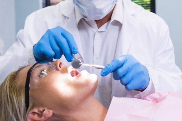 Patient receiving orthodontic dental examination to improve oral health and alignment.