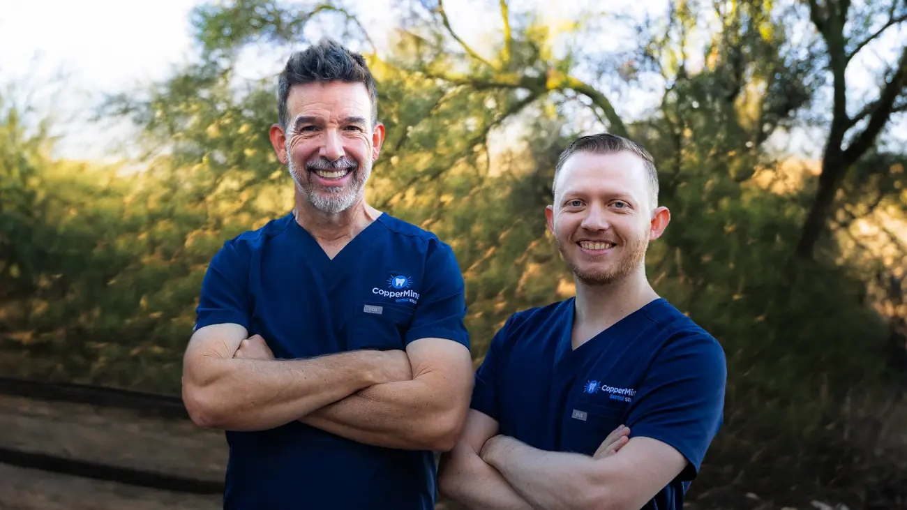 Two CopperMine dental professionals smiling outdoors in Green Valley, Arizona.